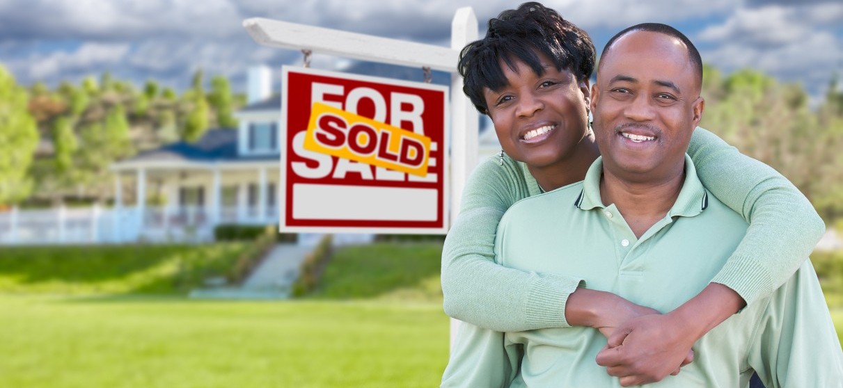 Couple in Front of Sold Sign